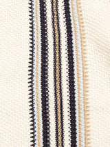 Close-up of the Cappa Stripe Cardigan - Whitecap by Blue de Gênes, showcasing a textured cotton fabric with vertical stripes in black, white, beige, and light blue. The surface has small raised dots that enhance its woven pattern.