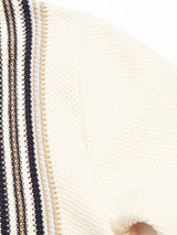 A close-up of the Cappa Stripe Cardigan - Whitecap by Blue de Gênes reveals textured beige knit with vertical black, white, and gray stripes, enhancing its cozy cardigan-like look. Crafted from soft cotton yarn, this simple design showcases elegance.
