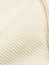 A close-up of the Blue de Gênes Cappa Stripe Cardigan - Whitecap showcases a thick, cream knit fabric with cozy striped patterns of small, raised interlocking stitches that evoke warmth and comfort.