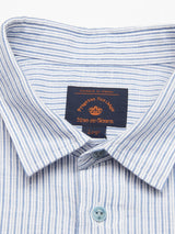 Close-up of the Enrico Grass Shirt - Navy Stripe by Blue de Gênes, showcasing its blue and white stripes, corozo logo buttons, orange brand label, prominent collar, and a cotton/linen blend.