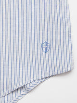 The Enrico Grass Shirt by Blue de Gênes features navy and white stripes with a small embroidered shield logo near the corner. Made from lightweight, textured cotton/linen, it seamlessly blends elegance with comfort.