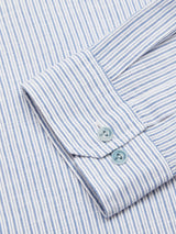 Close-up of a Blue de Gênes Enrico Grass Shirt in navy stripe, featuring soft light blue corozo logo buttons. The evenly spaced vertical stripes on the cotton/linen blend fabric appear neatly pressed.