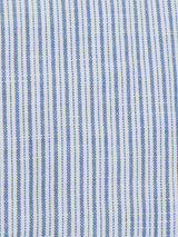 Close-up of a fabric pattern with vertical blue and white stripes. The Enrico Grass Shirt by Blue de Gênes displays blue stripes in a subtle checkered design on a plain white cotton/linen blend background, enhanced with elegant corozo logo buttons.