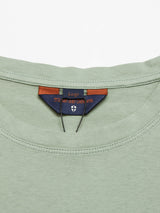 Green Salty Logo T-Shirt in soft cotton-jersey with a close-up neckline and tag featuring an orange and blue label with text and shield logo. This regular fit shirt has chest embroidery, is size large, and crafted by Blue de Gênes.
