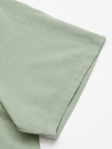 Close-up of a Green Bay Salty Logo T-Shirt from Blue de Gênes, featuring regular-fit short sleeves. The cotton-jersey fabric looks soft with visible stitching near the hem on a plain white background.