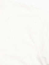 Close-up of the BdG S/S Grandad - Snow White by Blue de Gênes, highlighting its texture and stitching near the shoulder. The cotton slub yarn offers a soft, lightweight feel with subtle shadows accentuating its contours.