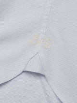 Close-up of the Basso Dob Shirt - Blue Water by Blue de Gênes, featuring a light blue fabric with subtle checks and yarn-dye stripes. Embroidered initials BG near the collar highlight exquisite European tailoring. The shirts crisp appearance is neatly tailored.