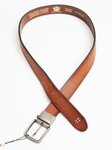 The FlexCord Belt - Cognac by Blue de Gênes is a brown full-grain leather belt with a textured surface and a sleek Magikflex buckle. It features interior branding and product details stamped in white, handcrafted in Italy, and presented in an open loop on a plain background.