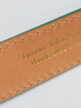 Close-up of a tan suede belt with green edges from Blue de Gênes, showing gold embossed text: Genuine Italian Leather and Handcrafted in Italy. The precise stitching highlights its artisanal quality, proudly made in Italy. Product Name: Suede Belt - Green Bay.