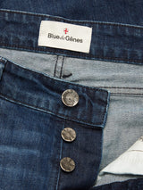 Close-up of Vinci Used Jeans by Blue de Gênes in blue regular fit, featuring three undone metallic buttons and an inner waistband label with a red-and-white crest. Made from comfort stretch denim for all-day ease.