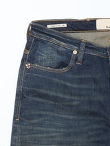 A close-up of the upper part of Blue de Gênes Repi Dark Vintage Jeans in mid blue denim shows the front pocket, belt loops, a metal accent, and an inside label with “Made in Italy” and an Italian flag.
