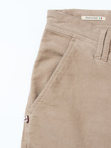 Close-up of Blue de Gênes BGpaulo Ottawa Trousers in Fungi, featuring light brown dobby corduroy fabric, front pocket, belt loop, and a Made in Italy label with an Italian flag on the inside waistband.