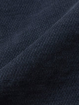 Close-up of dark navy textured fabric with visible weave and soft folds, reminiscent of the luxurious material used in Blue de Gênes BGpaulo Ottawa Trousers, made in Italy.