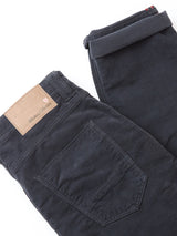 A pair of folded BGpaulo Ottawa Trousers in dark navy by Blue de Gênes, featuring a brown leather waistband patch and visible back pocket, made in Italy, displayed on a white background.