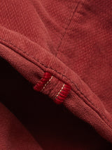 Close-up of soft dobby corduroy on Blue de Gênes BGpaulo Ottawa Trousers - Henna, featuring visible stitching and a small loop in thick red thread with white accents—reflecting the refined craftsmanship of the Ottawa line.