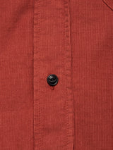 Close-up of the Zamboni Velu Shirt - Henna by Blue de Gênes: red baby corduroy with vertical ridges and a black button on the placket, showcasing classic garment-dyed detailing inspired by Blue de Gênes craftsmanship.