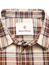 Close-up of the Robertino Brush Shirt - Stone by Blue de Gênes, featuring a beige, brown, and red brushed collar with a blue brand label, made in Portugal, and a red and white shield logo inside.