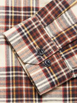 Close-up of the Blue de Gênes Robertino Brush Shirt - Stone: plaid flannel in beige, brown, orange, and black, with a buttoned cuff, herringbone weave, detailed stitching. Crafted in Portugal from premium Sidogras cotton.