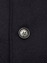 Close-up of the Shiba Melton Coat - Dark Navy by Blue de Gênes, showcasing a round, engraved four-hole button securely stitched on, adding refined detail to this classic Italian Melton wool peacoat.