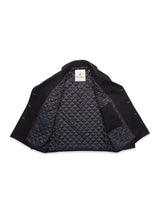 A Blue de Gênes Shiba Melton Coat in dark navy is shown open, displaying its quilted diamond-pattern lining, an inner left pocket, and a neck tag with red text that highlights the quality Italian Melton wool.