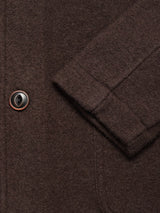 Close-up of the Blue de Gênes Kojima Wool Jacket - Chocolate, highlighting its textured brown boiled wool, a black and brown button, visible stitching, pocket seam, and part of the sleeve for a classic look.