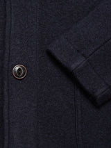 Close-up of the Blue de Gênes Kojima Wool Jacket - Navy, showing its textured boiled wool fabric, single brown button, and part of a pocket with visible stitching.