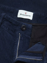 Close-up of Blue de Gênes Etsu Cord Chino - Navy in a relaxed fit, showcasing corduroy chino fabric, partially open zipper, black button, and a white brand label sewn inside the waistband.