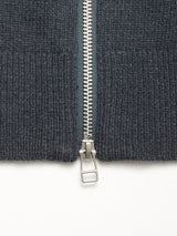 Close-up of a silver zipper partially unzipped on the thick, dark slate Nuvali Polo Cardigan by Blue de Gênes, shown against a white background.