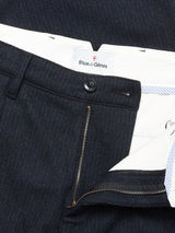 Close-up of the Kibishi Solid Pant - Dark Navy by Blue de Gênes, highlighting the waistband and fly with zipper and button closure, a white inner lining, and the Blue de Gênes label.