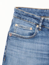 Close-up of the front pocket on Vinci Girisha Used Jeans by Blue de Gênes, highlighting stitching, a riveted coin pocket, and a shield-shaped patch with a red cross on white at the edge of this classic five-pocket style.