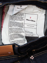 The inside label of Blue de Gênes Vinci Girisha Rinse Jeans - Rinse Wash displays brand and care tags, product info, and stitching on dark blue comfort stretch denim.