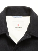 Close-up of the Vincenzo Solid Jacket - Dark Navy by Blue de Gênes. The label displays the brand with a red and white shield logo, while the white inner lining features a blue-striped neck tag.