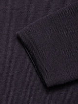 Close-up of the Toyama Knit L/S sweater by Blue de Gênes in dark navy, highlighting its textured waffle-knit pattern and folded edge lying at an angle on matching fabric.