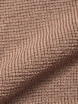 Close-up of the Porto Polo Knit - Fungi by Blue de Gênes, highlighting its light brown textured ribbed fabric and diagonal fold—showcasing casual elegance in every detail.