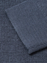 Close-up of a ribbed, dark slate knit fabric from the Porto Polo Knit by Blue de Gênes, with a folded section diagonally across the surface to showcase its luxurious texture and pattern.