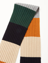 The Blue de Gênes Comforto Knit Scarf - Multi Stripe is a ribbed scarf featuring wide horizontal stripes in dark green, gray, mustard yellow, black, cream, and beige, displayed on a white background.