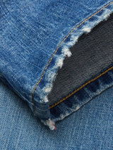 Close-up of the frayed hem on a Blue de Gênes Marco Used Jeans leg, with orange stitching and visible white threads. Made from 100% cotton denim in classic indigo wash with textured details.