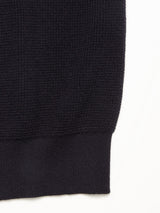 Close-up of the lower portion of the Otia L/S Polo Knit - Navy by Blue de Gênes, highlighting the knit pattern and ribbed hem against a plain white background.
