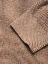 Close-up of the Blue de Gênes Gifu Knit Cardigan in chocolate, crafted in a wool blend with ribbed cuffs, shown overlapping a waffle-knit textured background.