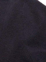 Close-up of a dark, textured fabric with a subtle grid pattern and visible seams, likely part of the Blue de Gênes Gifu Knit Cardigan in Navy.