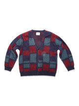 The Blue de Gênes Block Knit Cardigan - Navy Pattern is a fuzzy wool-blend, V-neck cardigan with bold red, teal, and navy checkerboard squares, long sleeves, relaxed fit, and a classic button-up style.