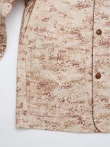 Close-up of the BGkendrick Print Jacket - Multi Pattern by Blue de Gênes, highlighting its beige and brown camo design, large front pocket, sleeve detail, buttons, and textured fabric against a white background.