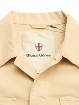 A close-up of the Blue de Gênes BGhunter Vecchio Jacket in pale khaki, featuring a visible inner label with the red and white shield logo, neatly arranged against a white background.