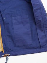 The image displays the interior of the BGcanopy Jacket - Navy Peony by Blue de Gênes, featuring a large sewn-on inner pocket, beige lining accents, and a blue-and-white drawstring with brown detailing along the edge.