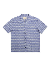 The BGforma Onda S/S Shirt by Blue de Gênes is a short-sleeved, oversized resort shirt with a blue and white pattern, spread collar, chest pocket, and made of 100% cotton. Laid flat on a white background.