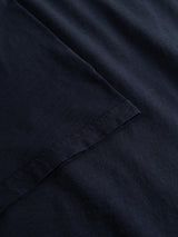 Close-up of the BGoscar T-Shirt - Dark Navy by Blue de Gênes, highlighting its classic crewneck, 100% cotton fabric, and neatly stitched sleeve hem, laid flat on a matching background.