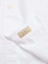 Close-up of a crisp, textured BGsander Oxford Shirt - White by Blue de Gênes, featuring a button-down collar and beige tag on the pocket. Made from 100% cotton for lasting comfort.