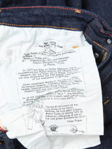 A close-up of the inside pocket of Blue de Gênes Repi Dai V Dark V2 Jeans in dark blue denim shows a white lining with printed details on Renzo Piano, architecture, art, and a sketch, framed by durable fabric and sturdy stitching.