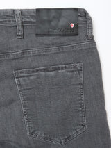 Close-up of the back of Blue de Gênes BGrepi Giulio Light V2 Jeans in grey comfort stretch denim, showing a rear pocket and a black leather brand patch with a red and white shield emblem.
