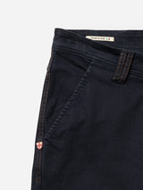 Close-up of Blue de Gênes BGpaulo Pavia 1 V2 Chino in Midnight Blue, featuring orange stitching, a side pocket, a red and white shield patch near the seam, and a Made in Italy label sewn inside the waistband.